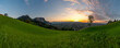 Panorama Sonnenuntergang über den Schweizer Bergen im Rheintal, einzelner Baum mit Blick auf Dornbirn, Vorarlberg, Austria. leuchtendes Abendrot, tolle Stimmung mit roten Wolken über den grünen Wiesen