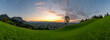 Panorama Sonnenuntergang über den Schweizer Bergen im Rheintal, einzelner Baum mit Blick auf Dornbirn, Vorarlberg, Austria. leuchtendes Abendrot, tolle Stimmung mit roten Wolken über den grünen Wiesen