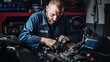 © Meow Creations - Professional auto mechanic working in auto repair shop, repairing car engine.