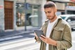 © Krakenimages.com - Young hispanic man smiling confident using touchpad at street