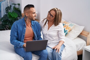 Wall Mural - Man and woman mother and son using laptop at bedroom