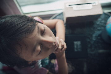 Child girl praying on bible with light in morning at home, christian concept, view from above.