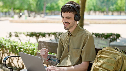 Sticker - Young hispanic man tourist using laptop and headphones celebrating at park