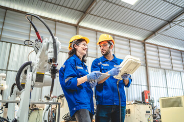 engineer people service robot working in automation factory. worker team in safety suit work robotic