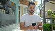 © Krakenimages.com - Young hispanic man using smartphone with serious expression at street