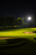 Beautiful dark night view of the golf course, Bunkers sand and green grass, garden background In the light of the spotlight underexposure view.