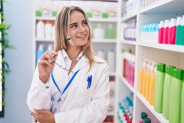 Sticker - Young blonde woman pharmacist smiling confident holding glasses at pharmacy