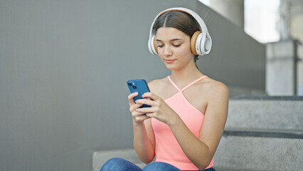 Sticker - Young beautiful girl using smartphone and headphones at school