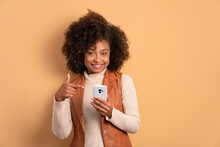 Happy African American Woman Smiling And Holding Mobile Phone In All Beige Colors. Network, Messaging, Internet Concept.