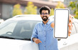 © Prostock-studio - Happy young indian man standing by auto, showing phone