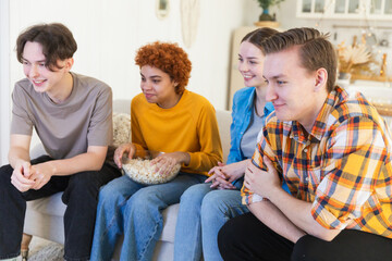 Wall Mural - Group of friends watching sport match soccer football game on tv. Happy football fans celebrating victory at home. Friendship sports entertainment concept. Diverse buddies having fun together at home