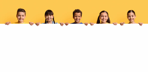 Happy smiling group of kids showing blank placard board