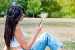 © boryanam - Beautiful Brunette Woman using her phone in the summer park
