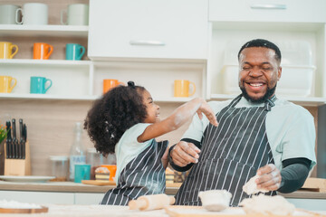 Wall Mural - Kind African american parents teaching their adorable daughter how to cook healthy food, free space of kitchen, Happy black people family preparing healthy food in kitchen together