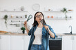 © sofiko14 - Asian female having fun with whisk while cooking at home