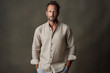 Handsome 40 years old man in linen shirt on earthy tones background