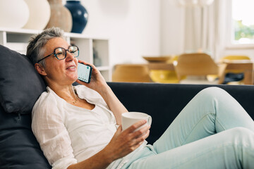 Senior woman is talking with a friend using a mobile phone.