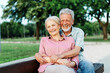 © Lumos sp - woman man senior couple happy retirement together elderly hug active bonding park outdoor sitting bench leisure fun smiling love old nature wife happiness mature