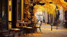 A Sidewalk With Tables And Chairs And A Tree With Yellow Leaves