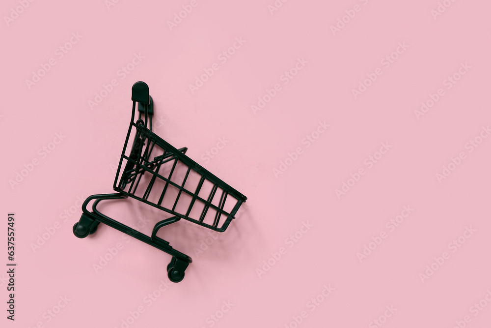 Small shopping cart on pink background