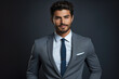 © vefimov - Poised and confident businessman is captured in this image, wearing a grey suit and a blue shirt. His professional demeanor and approachable smile make him an ideal representation of business success.