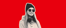 Portrait Of Blonde Young Woman Listens To Music With Headphones Wearing Sunglasses And Black Hat On Red Background
