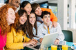 © Xavier Lorenzo - Young group of happy student friends standing together while studying on laptop. Smiling portrait of international high school classmates. Education and teamwork concept.