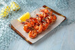 Grilled king prawns on a blue background. Mediterranean Kitchen. Sea mood menu.