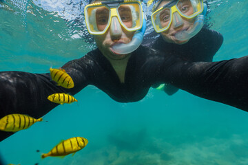 Canvas Print - young couple doing snorkeling with stinger suits in the great barrier reef