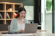© ArLawKa - Asian woman using laptop computer and working at office with calculator financial documents on table Planning analysis of financial reports in the office