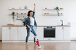 © sofiko14 - Female vacuuming floor while listening music in headphones