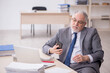 © Elnur - Old male employee working in the office