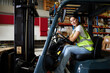 © offsuperphoto - portrait female worker driving a forklift in the warehouse storage