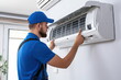 Male technician cleaning air conditioner