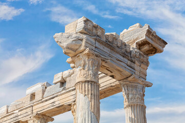 Wall Mural - Temple of Apollo in Side (Turkey). Close up fragment of the entablature of the ruined temple. Stone-cut relief on the frieze. Scenic clouds as background. History, art or architecture concept