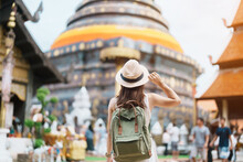 Young Asian Woman Traveler In White Dress With Hat And Bag Traveling In Wat Phra That Lampang Luang, Tourist Visit At Lampang, Thailand.. Asia Travel, Vacation And Summer Holiday Concept
