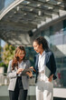 © Nuttapong punna - Business woman team going in city center in smart casual business style, talking, working together, stylish freelance people, holding coffee and laptop,tablet and smartphone discussing.
