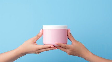 Canvas Print - Pink background with a female hand holding a blue jar of cosmetic cream for branding and mockup purposes Copious space available