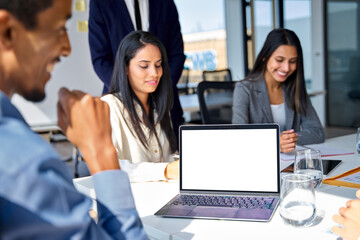 Busy diverse professional business team people working together at office group meeting with laptop computer mock up white blank screen on board room table. Mockup template corporate online service ad