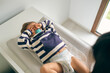 © ADDICTIVE STOCK CORE - Toddler in nappy lying on changing table and rubbing eyes