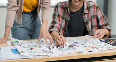 UX developer and ui designer brainstorm about mobile app interface wireframe design with customer breif and color code at office