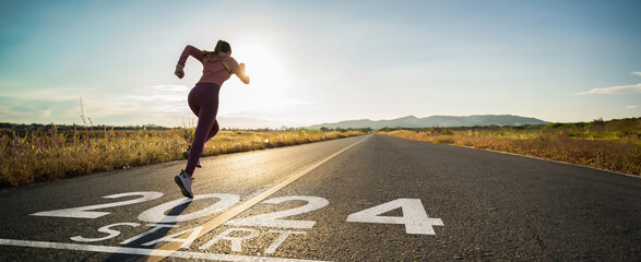 new year 2024 or start straight concept.word 2024 written on the asphalt road and athlete woman runn