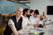 © Johnér - Woman sitting during business meeting and looking at camera