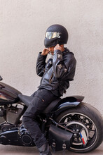 Mature Biker In Leather Clothes Putting On Helmet