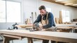 © Meow Creations - Carpenter working on a wooden plank in a carpentry workshop
