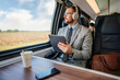 © Dusko - Handsome businessman is having a good time while traveling by high-speed train. He is using laptop computer and wireless headphones for online communication, gaming and entertainment.