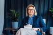 © okrasiuk - Portrait of smiling 50's stylish, confident mature businesswoman, middle aged company ceo director, experienced senior female professional, business coach team leader in modern office. Female leader