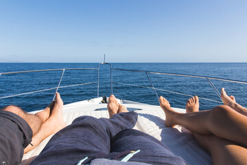 Young tourists relaxing and sunbathing over a sports yacht in the Galápagos Islands during a cruise around Santiago Island.