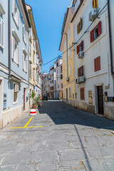 A view up a wide side street in the town of Piran, Slovenia in summertime