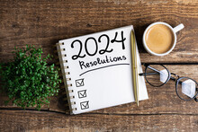 New Year Resolutions 2024 On Desk. 2024 Resolutions List With Notebook, Coffee Cup On Table. Goals, Resolutions, Plan, Action, Checklist Concept. New Year 2024 Template, Copy Space